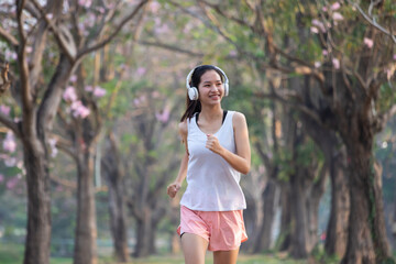 Naklejka premium Healthy Teenage girl is jogging outdoors. Fitness girl running. Female exercising at outdoor park.