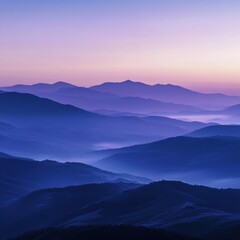 Fototapeta premium Tranquil mountain range silhouette at twilight with ethereal sky and fog