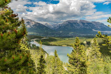 Views looking over Canmore in northern Canada during summer time from the Grassi Lakes trail with towering mountains surrounding the stunning, wilderness area.