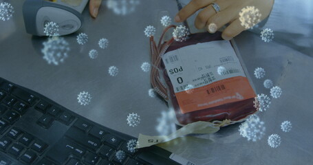 Blood donation bag on table with keyboard, highlighting virus awareness and safety