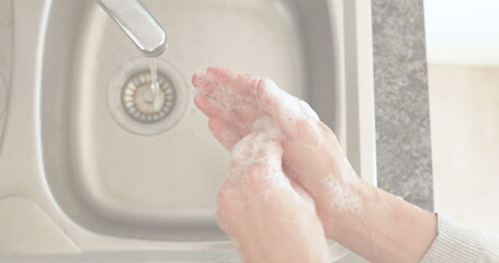 Fototapeta premium Washing hands with soap at kitchen sink for hygiene and safety