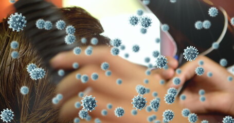 Image of cells spreading over hands of male hairdresser combing the hair of a male customer
