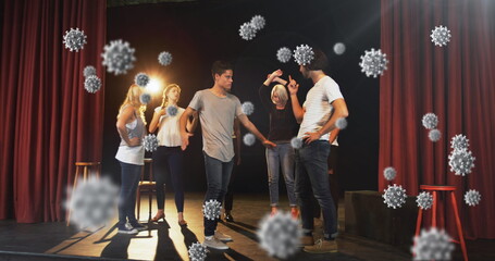 Image of cells moving over a group of male and female actors reheasing on stage at a theatre