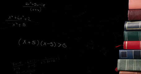 Image of mathematical formulae moving over stack of books on black chalkboard in the background