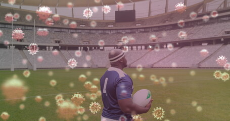 Image of 3d coronavirus cells floating over rugby player holding rugby ball on empty stadium
