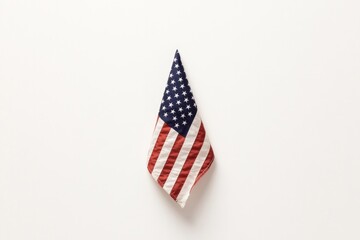 american flag neatly folded in triangle placed centrally on soft white backdrop creates solemn tribute