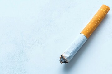 Obraz premium close-up of single unlit cigarette placed diagonally on plain white surface with ample copy space
