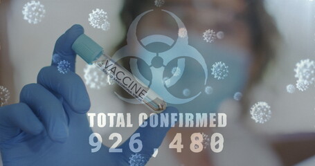 Image of biohazard sign covid 19 cells total confirmed rising with masked woman in lab