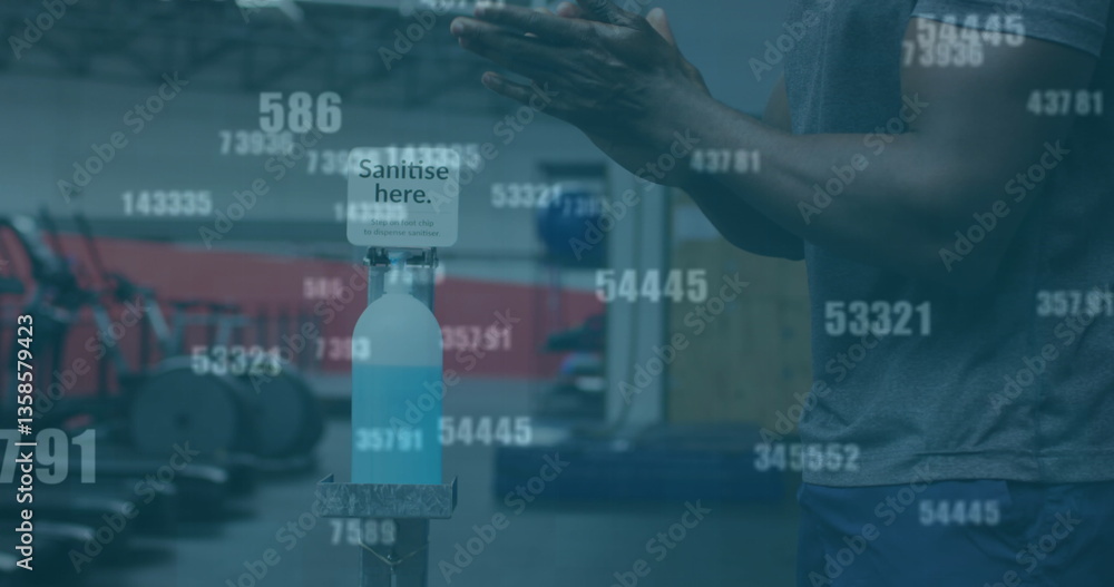 Poster multiple changing numbers against mid section of man using hands sanitizer at the gym
