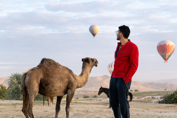 tourist with camels and hot air balloons in cappadocia turkey