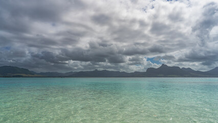 Beautiful tropical seascape. Crystal clear turquoise water. Ripples on the surface. Mountains in...