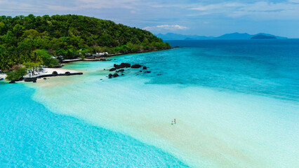 Fototapeta premium Explore the breathtaking beauty of Koh Kham Island Thailand, where soft sands meet crystal-clear turquoise waters. This tropical paradise invites relaxation and adventure under a clear sky.