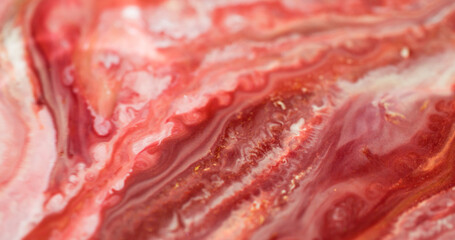 Sparkling fluid. Marble art. Defocused red crimson pink color shimmer paint in water liquid blend...