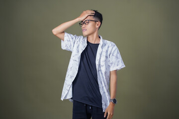 Asian man with glasses wearing white casual shirt. Dizzy, troubled, upset expression. Isolated on...