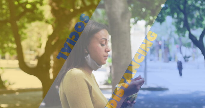 Social distancing text against african american woman with lowered face mask having a snack outdoors