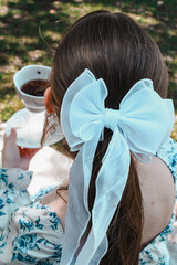 Tea Party, Woman Holding Tea Cup with White Bow in Her Hair