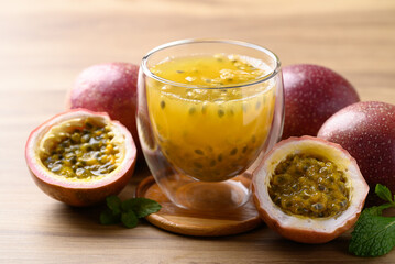 Glass of passion fruit juice with fresh passion fruit on wooden background, Healthy drink