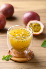 Glass of passion fruit juice with fresh passion fruit on wooden background, Healthy drink