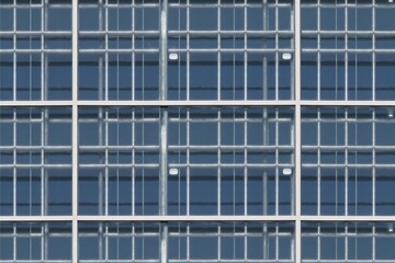 Modern Commercial Building Facade Featuring Geometric Glass Windows with Steel Framework in Urban Setting