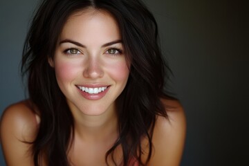 Naklejka premium Close up of a beautiful woman with a warm smile and dark brown wavy hair. Perfect for beauty, wellness, or positive lifestyle content.