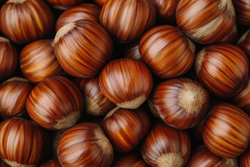 Obraz premium Pile of whole, ripe hazelnuts with smooth, striped brown shells. Great for recipes, healthy snacks, or autumnal-themed designs.