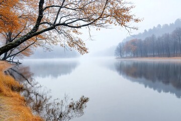 Obraz premium Serene lake reflecting colorful autumn trees and fog in the morning