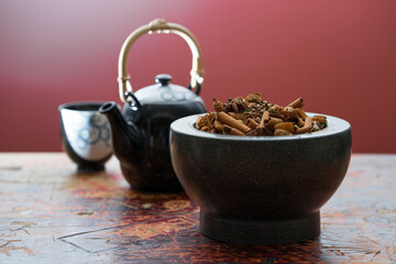 Fresh Loose Leaf Chai Spices on Rustic Table in Mortar with Tea Pot