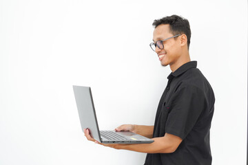A man is holding a black laptop and smiling