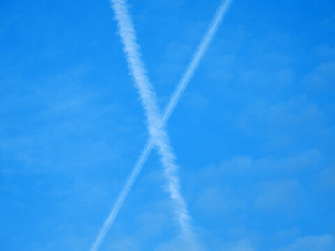 blue sky with white aircraft trails