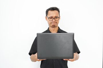 A man is holding a black laptop in his hands
