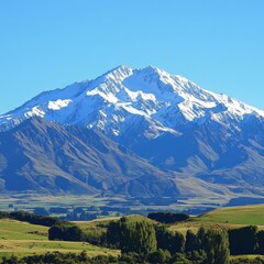 Fototapeta premium Majestic Snow-Capped Mountain Under Clear Blue Sky with Lush Greenery in the Foreground, Capturing the Beauty of Nature's Landscape in Stunning Detail