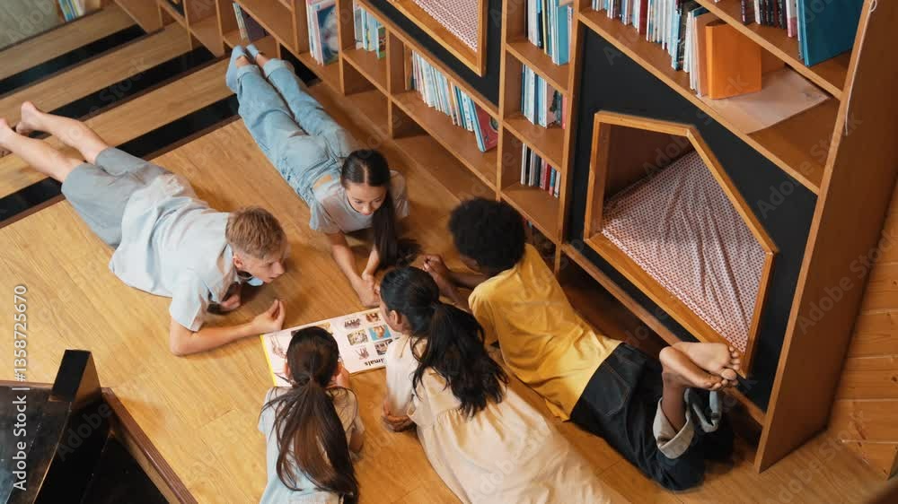 Poster group of diverse children lying down in circle while reading a book at library. top view of girl sha