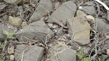 stones tied with wire for support to prevent landslides, river barriers made of stones wrapped in wire