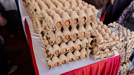Stacked egg cartons filled with brown eggs on display