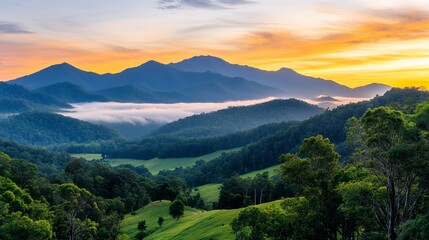 Obraz premium Serene Sunrise over Majestic Mountain Range and Lush Green Valleys Bathed in Golden Light