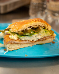Cemita Poblana. A traditional Mexican sandwich with breaded pork and chipotle chili, quesillo cheese, and papalo leaves.