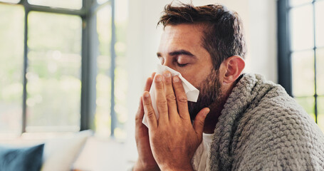 Sick, man and sneezing with blanket in home for flu symptoms, fever and respiratory disease on...
