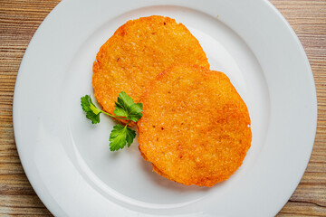 Two golden, crispy delights on a pristine plate, garnished with a sprig of greenery