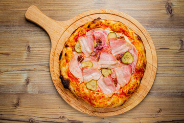 Succulent slices of ham and tangy pickles topped on fresh pizza, invitingly presented