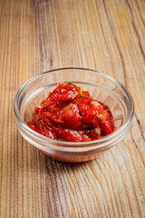Bursting with flavor, sun-dried tomatoes sit invitingly in a glass bowl, perfect for various dishes