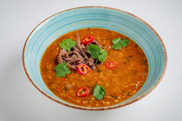 Savory beef stew with tender meat, spices, and vibrant herbs and chilies
