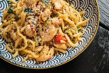 Stir-fried noodles with chicken, veggies, and a sprinkle of sesame seeds