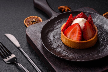 Round sweet tart with strawberry pieces and cream