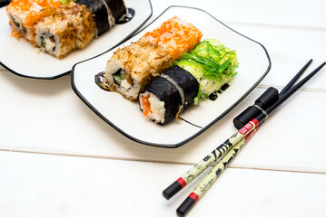 Several sushi on a white plate standing on a white background
