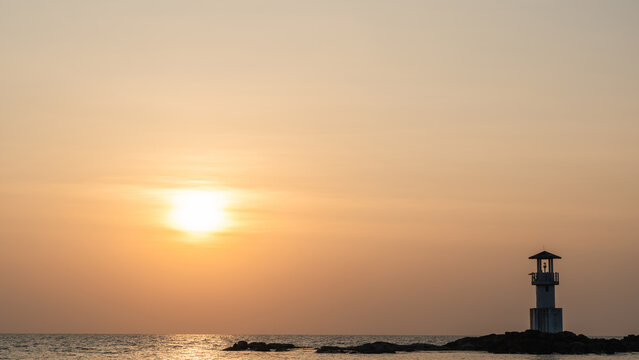 Light house on sea beach with sunset sky clouds in the evening, Beacon light tower for guiding travel coastline in golden hour sunlight background well space for text banner, Phang Nag, Thailand