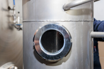 Industrial equipment close-up: stainless steel tank with valve and pipe fittings