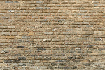 Rustic stone brick wall with mixed earth tones and uneven pattern