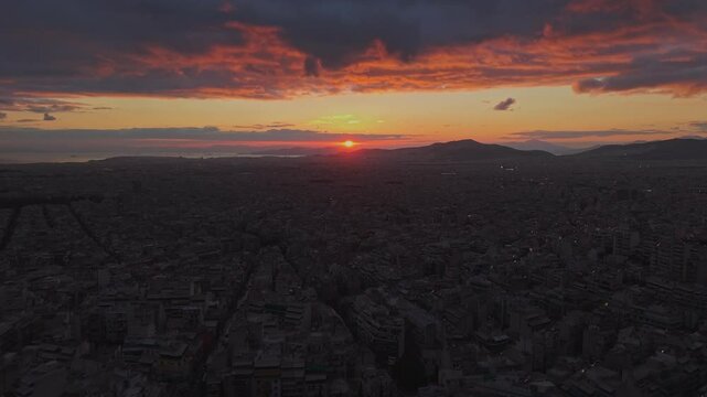 Stunning aerial panoramic sunset over Athens, Greece, vibrant orange and pink hues reflecting over the sprawling cityscape