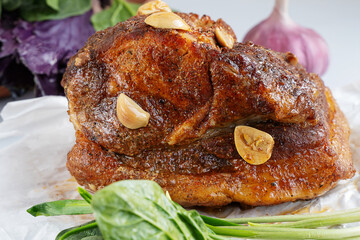 Delicious roast meat with garlic and herbs, served with fresh vegetables and wild garlic rampson on a white plate