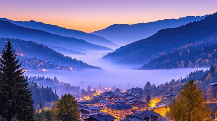 Obraz premium Misty mountain valley at dawn with village nestled in the valley.